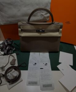 Alternative view of Hermès Kelly 32 retourne Nuova 2025 stampa K in pelle togo colore etoupe con hardware palladio  con tutti gli adesivi di protezione dell’imballaggio e dell’hardware.