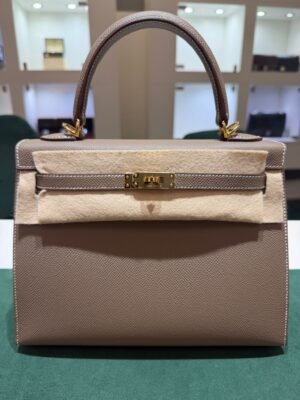Herm&egrave;s Kelly 25 Sellier Nuova 2026 stampa G in pelle Epsom colore Etoupe con hardware dorato con tutti gli adesivi di protezione dell&rsquo;imballaggio e dell&rsquo;hardware.