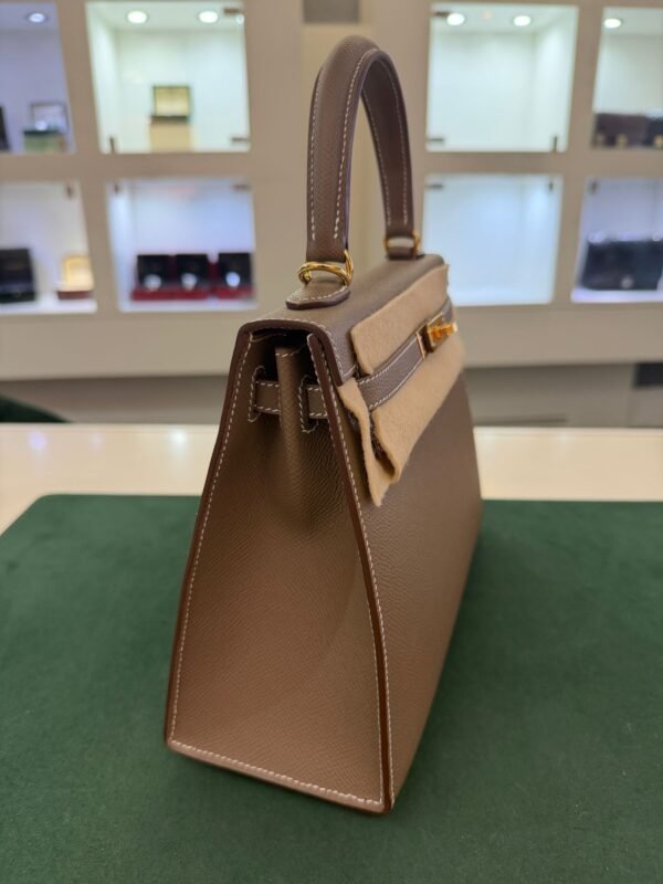 Herm&egrave;s Kelly 25 Sellier Nuova 2026 stampa G in pelle Epsom colore Etoupe con hardware dorato con tutti gli adesivi di protezione dell&rsquo;imballaggio e dell&rsquo;hardware.